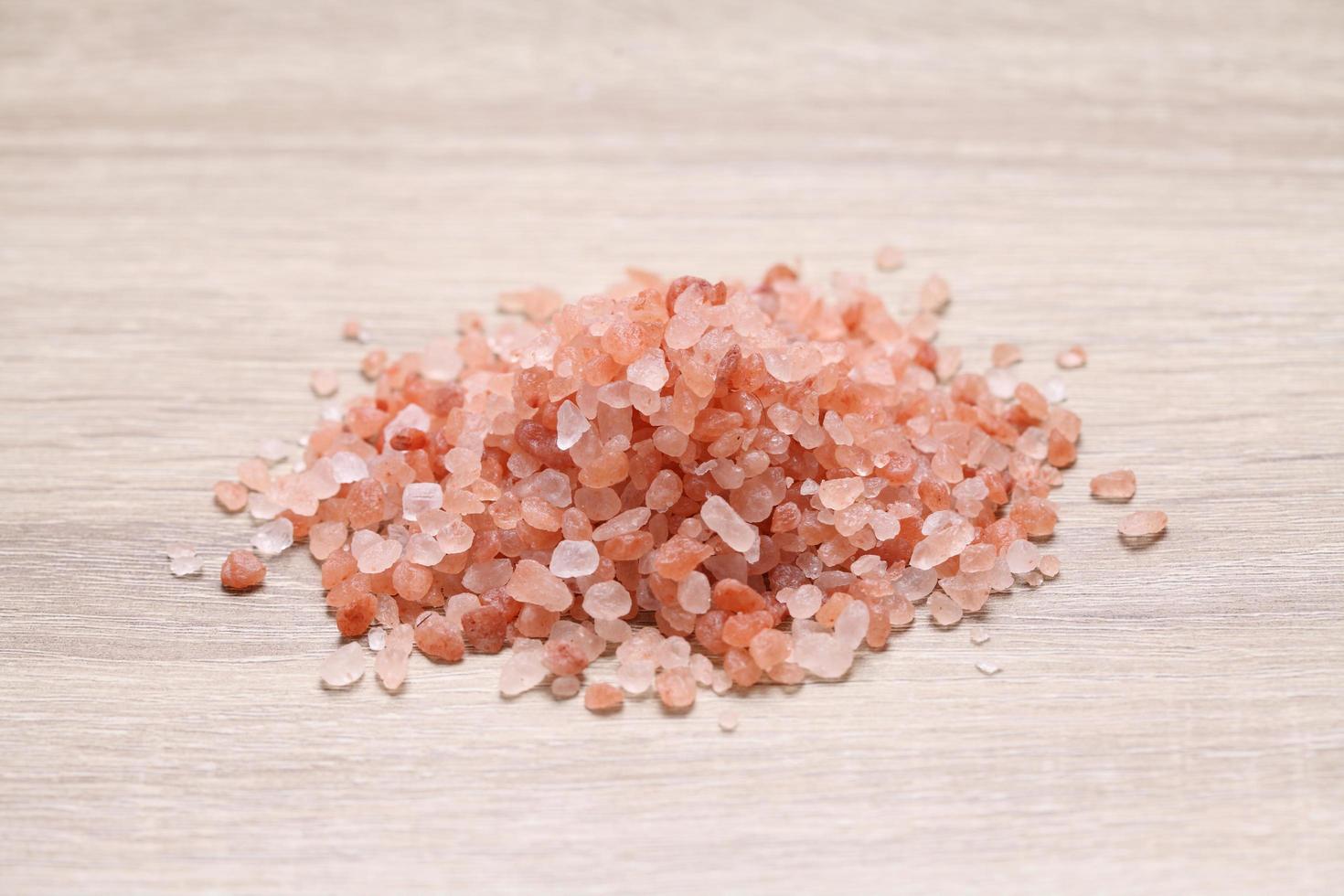 Close up Himalayan pink salt on wooden table photo