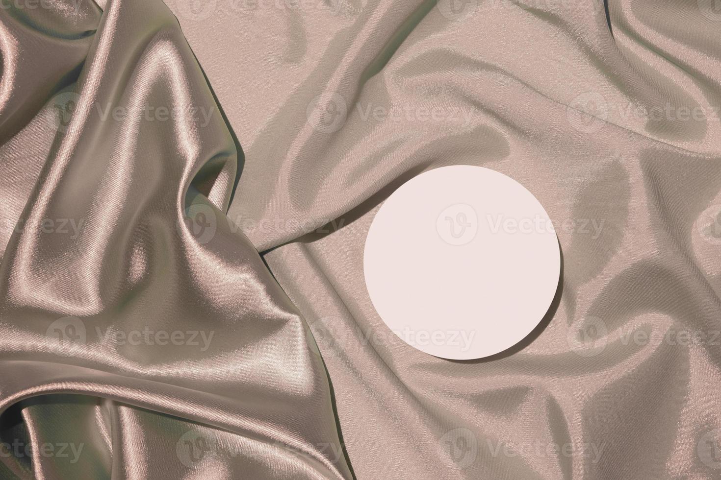 Folds of beige satin fabric and podium mock up top view photo