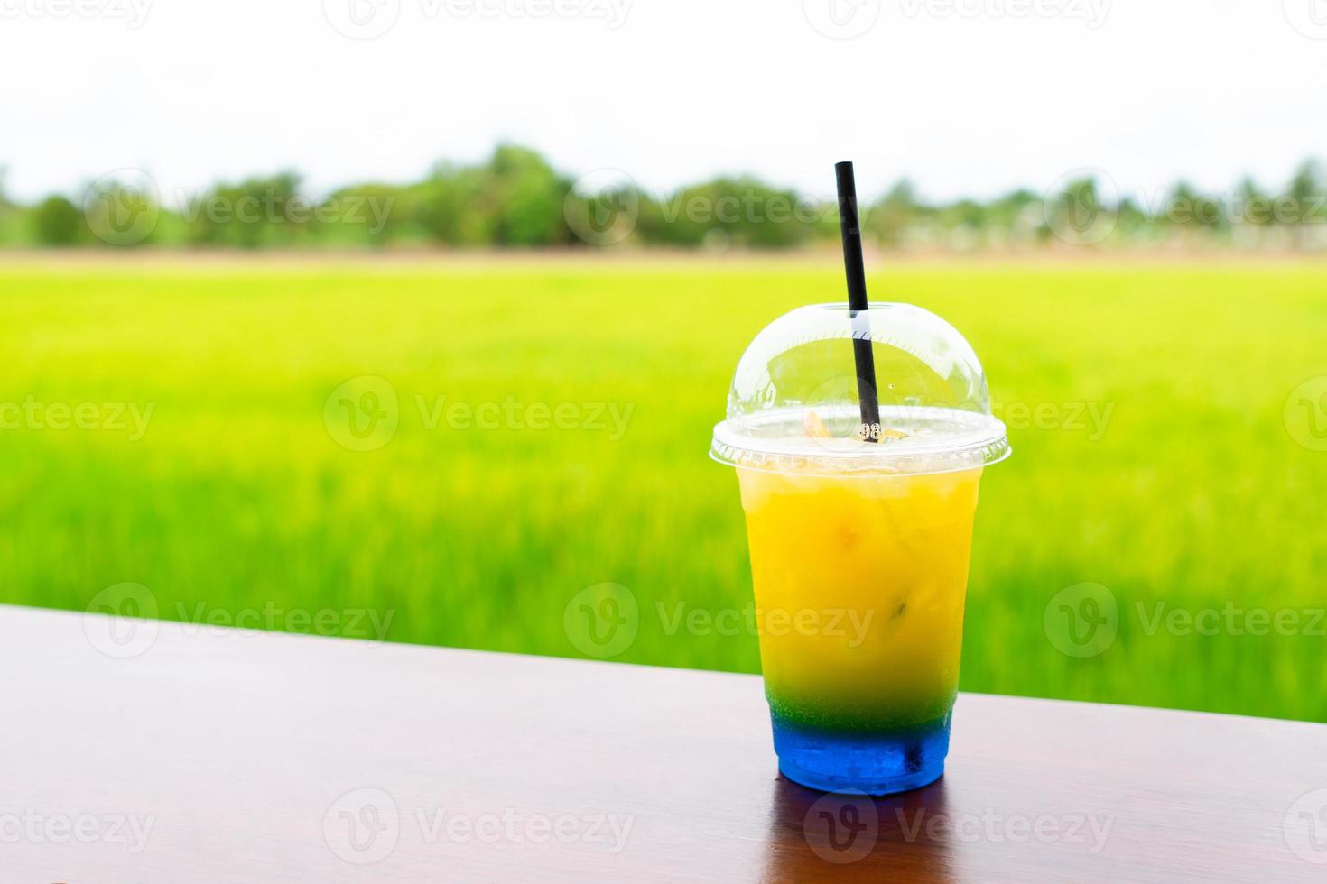 Lemonade soda served on table in cafe with paddy rice field background photo