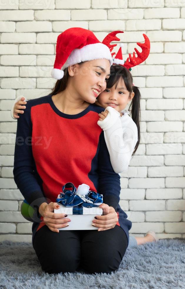 Asian mother gives Christmas present to daughter photo