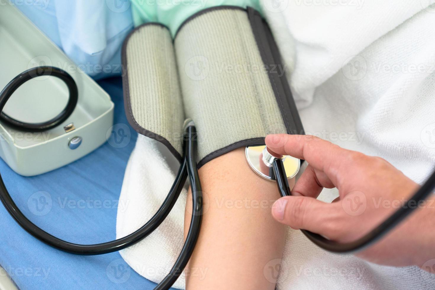 El médico mide la presión arterial del paciente. foto