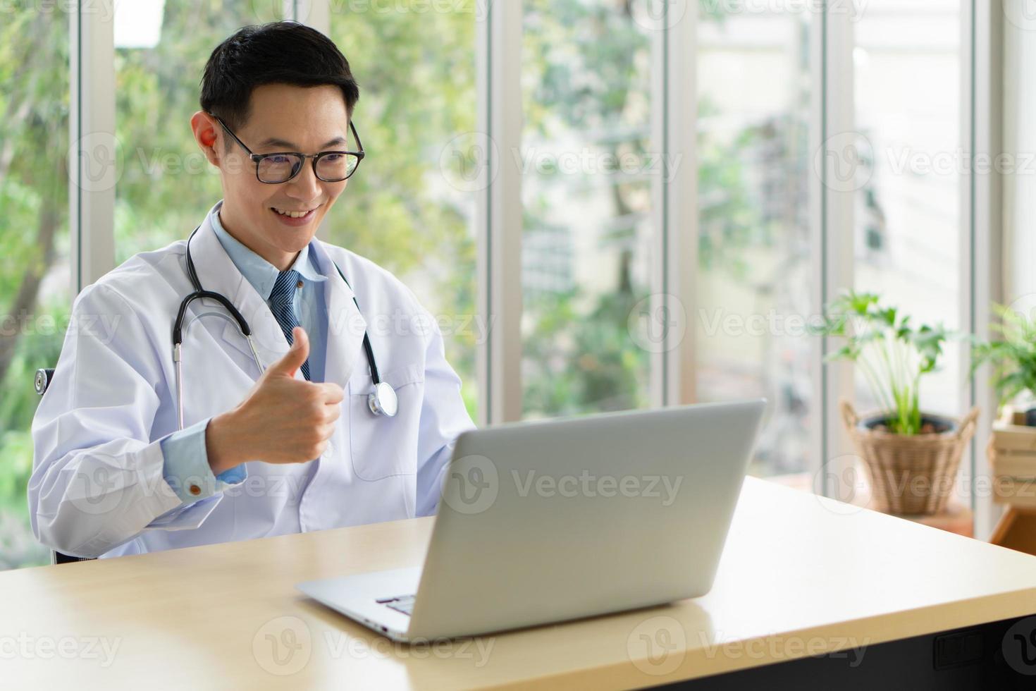 Joven médico asiático asistir a una reunión en línea en el hospital foto