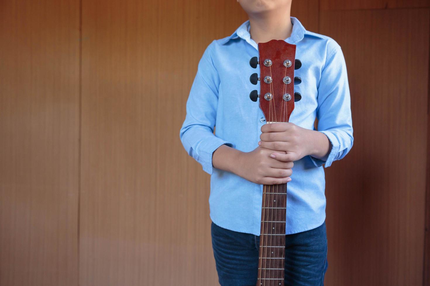 niño tocando la guitarra clásica con diversión foto