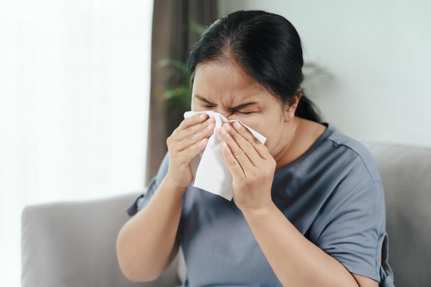 la mujer enferma tuvo alergia nasal al toser o estornudar con un pañuelo de papel. foto
