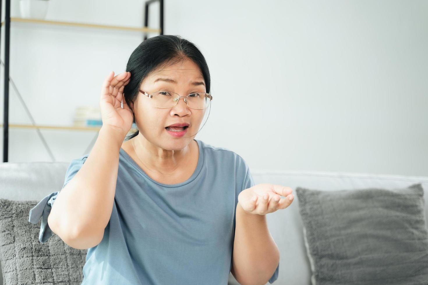 Deaf disabled woman having hearing problems hold his hand over the ear photo