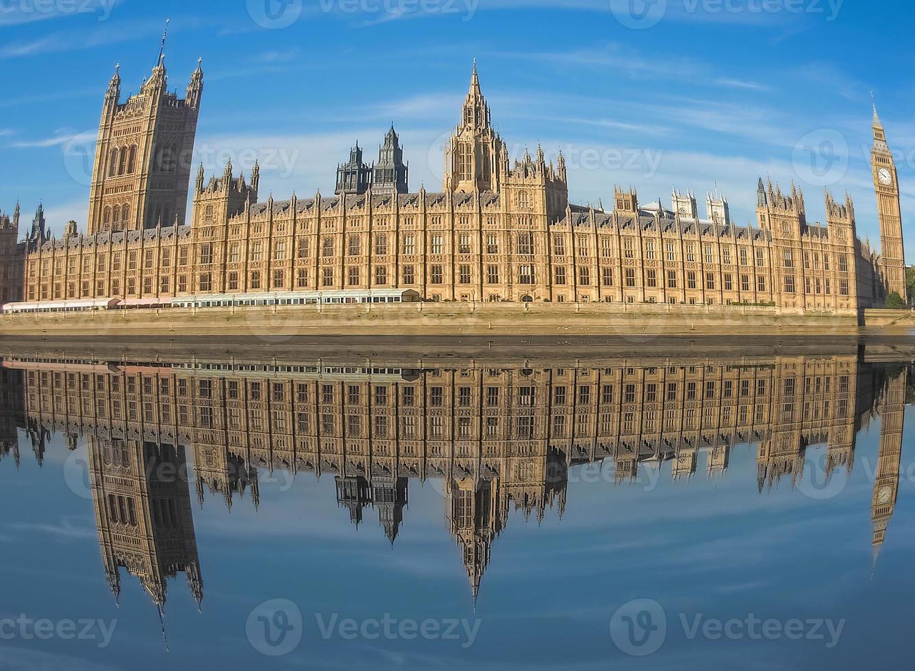 Houses of Parliament reflected in river Thames in London with fi photo