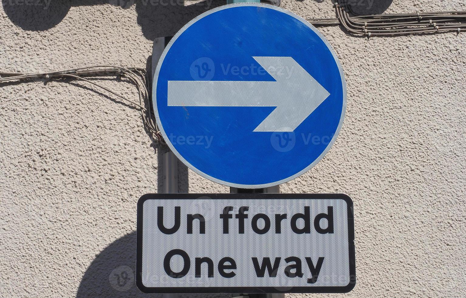 Right direction arrow sign. Un ffordd means One Way in Welsh. photo