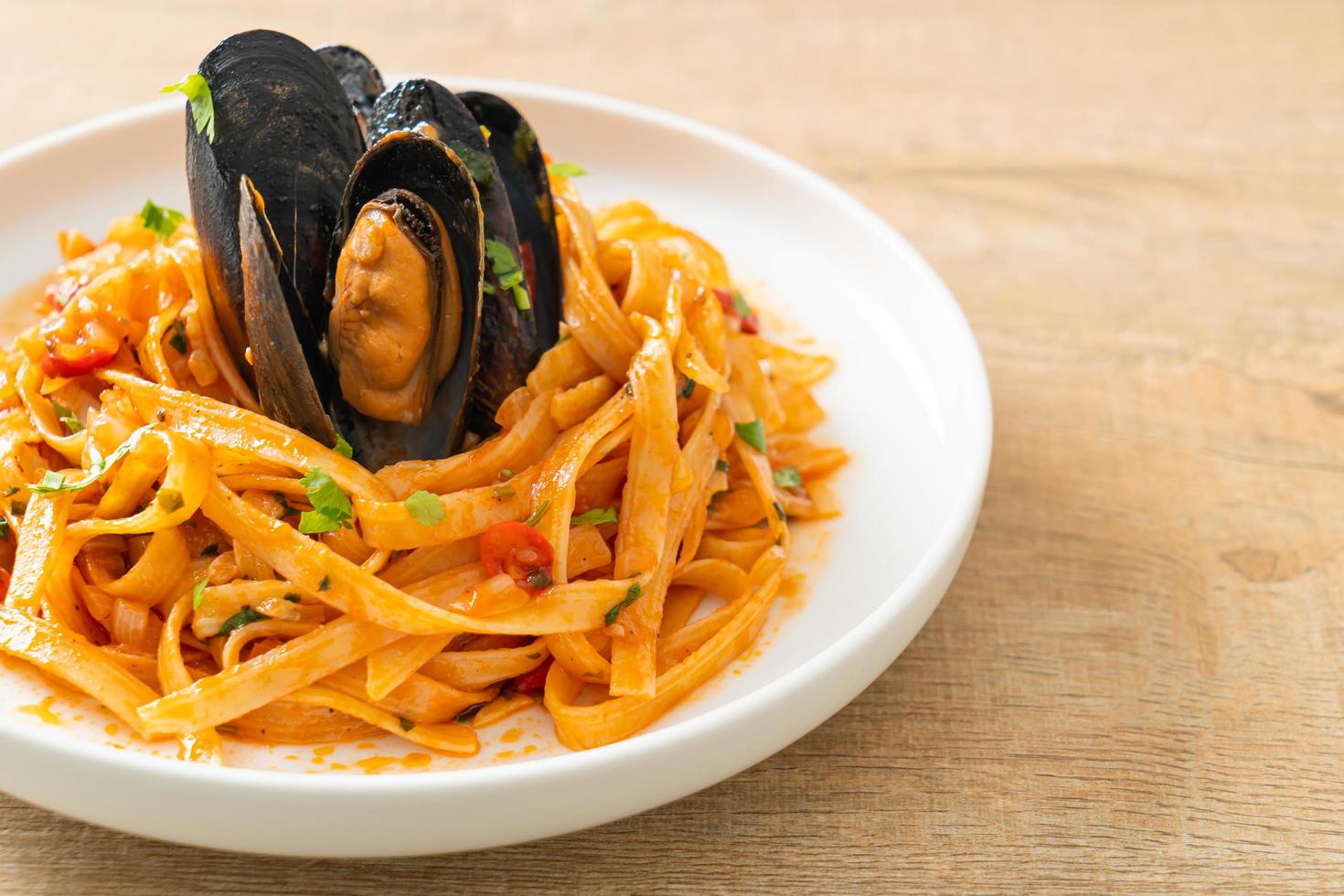 pasta de espagueti con mejillones o almejas y salsa de tomate foto