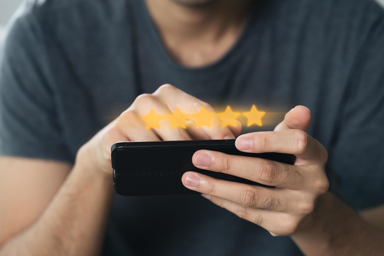 cliente hombre dando una calificación de cinco estrellas en el teléfono inteligente foto