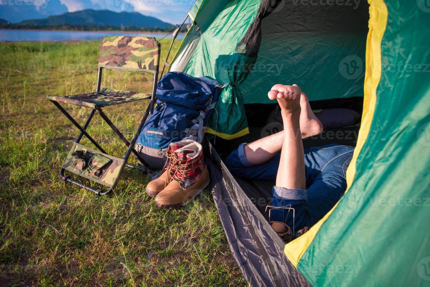 Close up of woman legs relaxing in camping tent photo