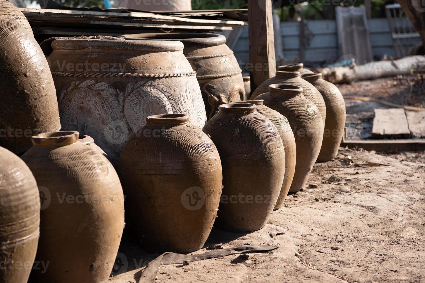 Old Thai traditional clay jars on outdoors ground photo