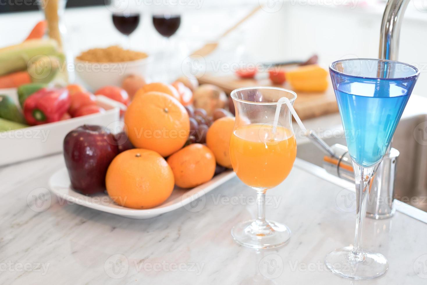 Frutas y jugos de frutas en el mostrador de mármol en la cocina. foto