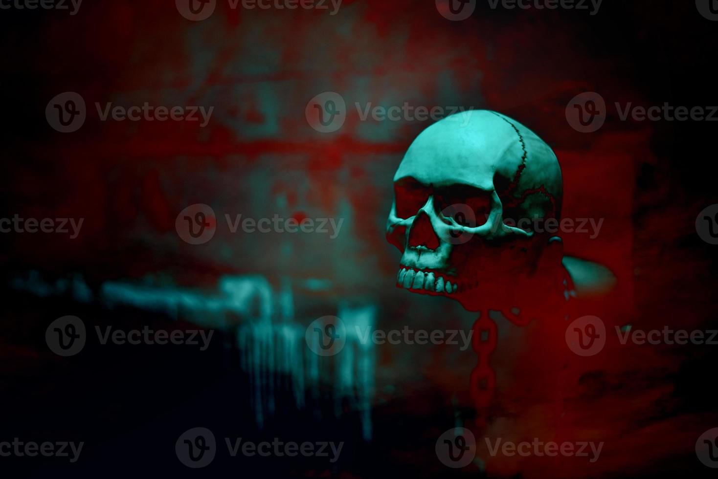 Esqueleto de cráneo con cadena en fondo rojo sangre foto