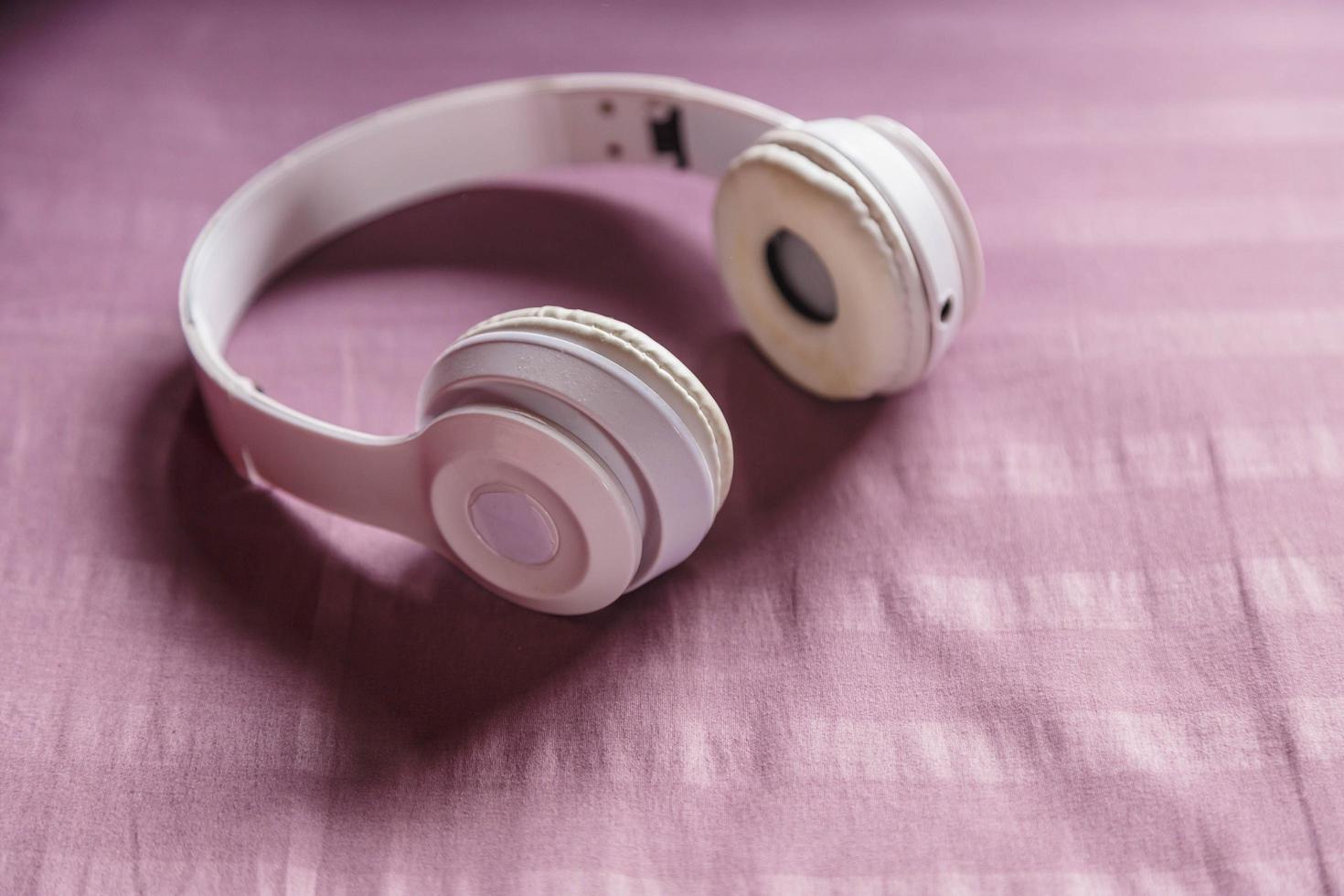 auriculares blancos sobre fondo morado. concepto de música. foto