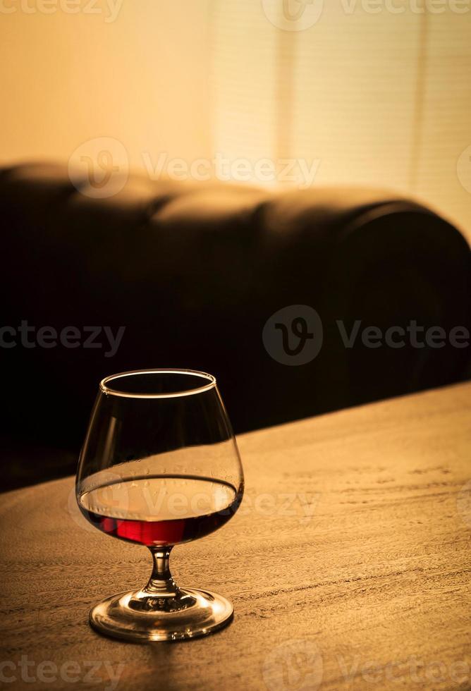 glass of french cognac brandy on cozy bar table detail photo