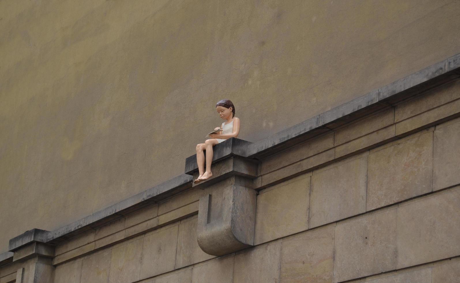 Girl with a paper plane on a wall photo