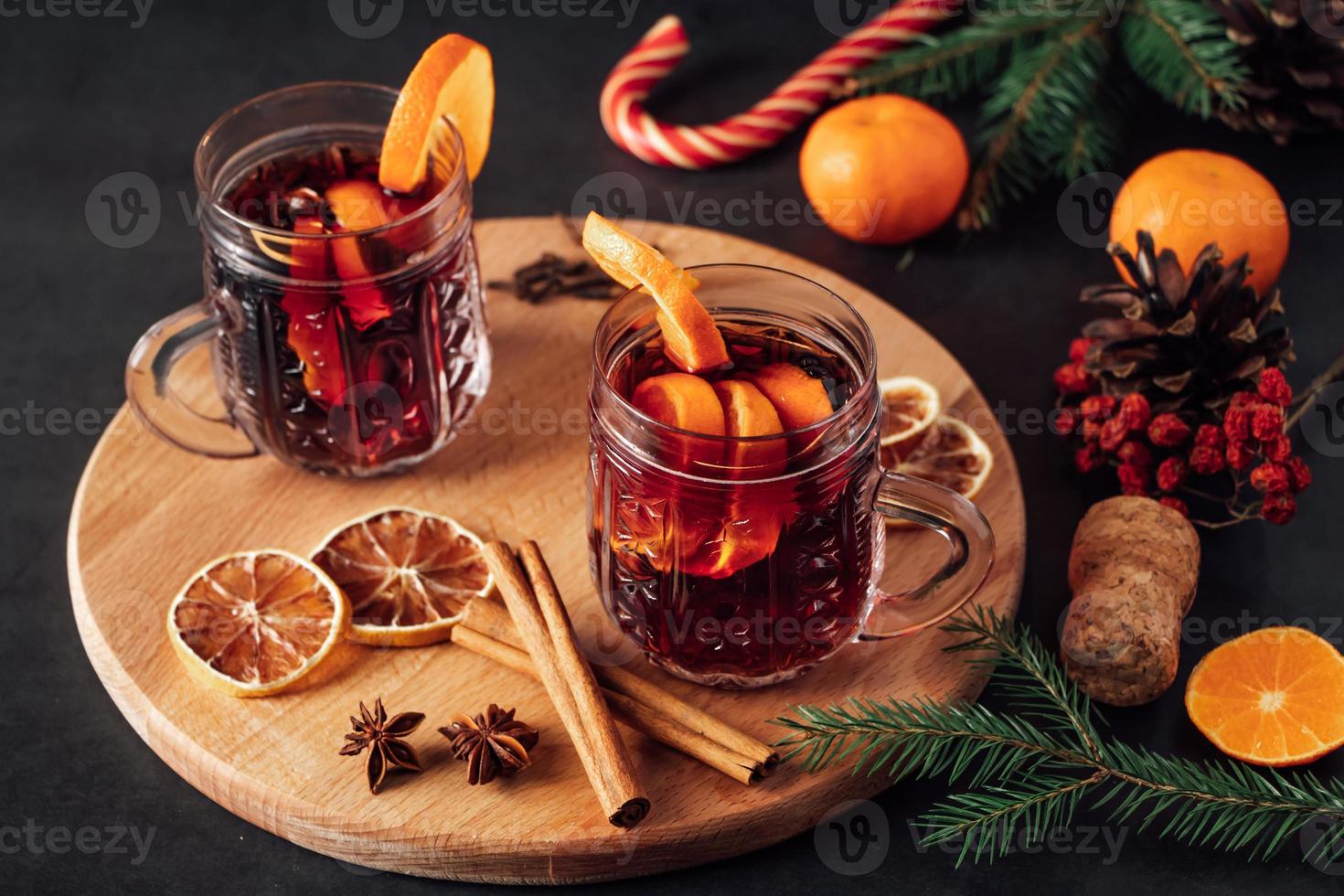 dos copas de vino caliente con frutas sobre fondo oscuro. foto