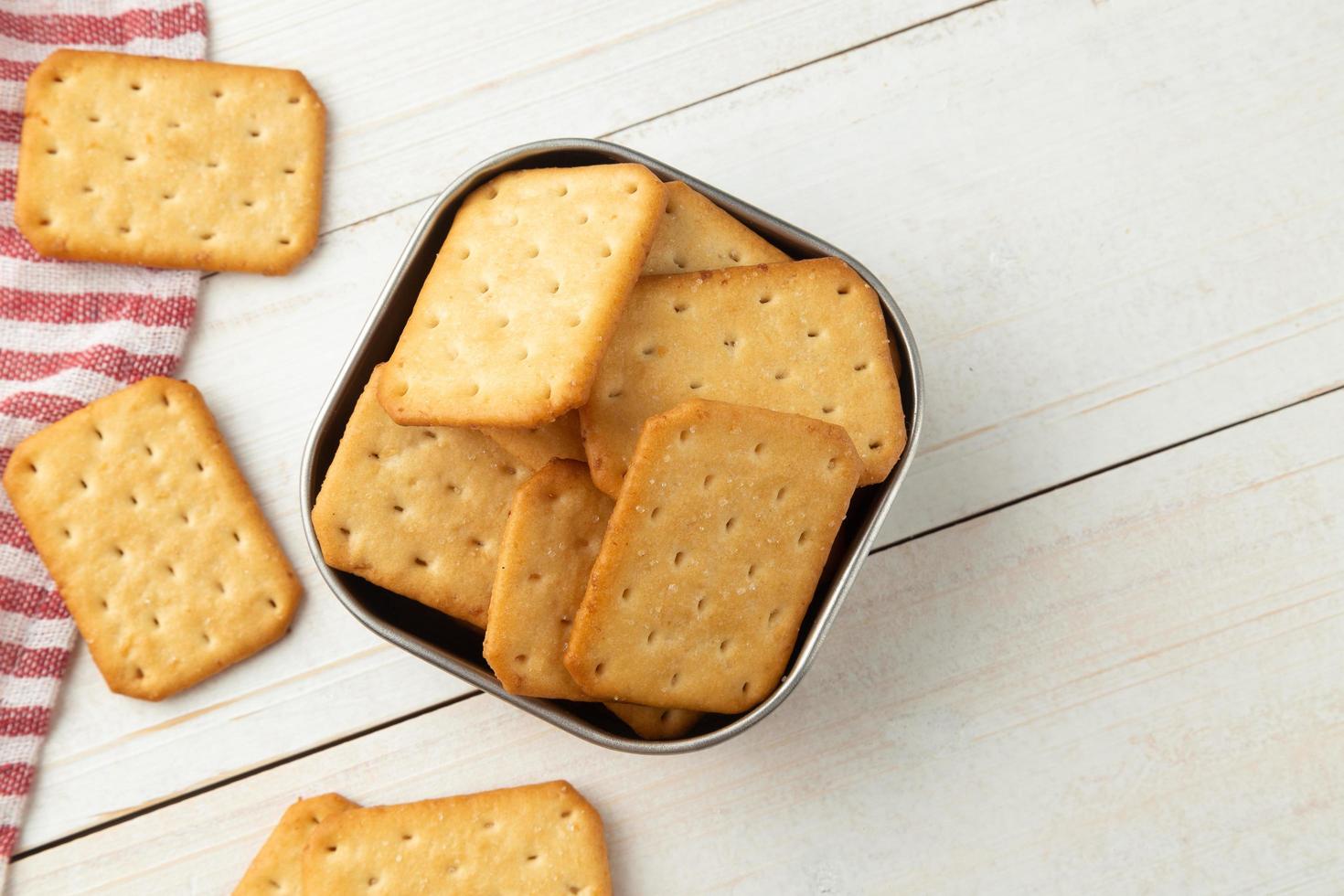 Cracker cookies in a stainless steel bowl with tablecloth photo