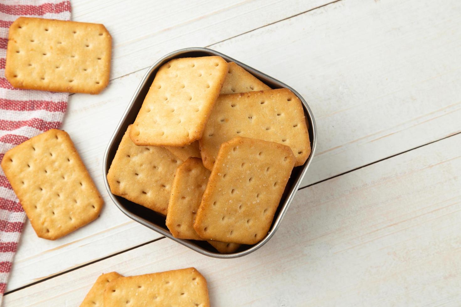 galletas saladas en un recipiente de acero inoxidable con mantel foto