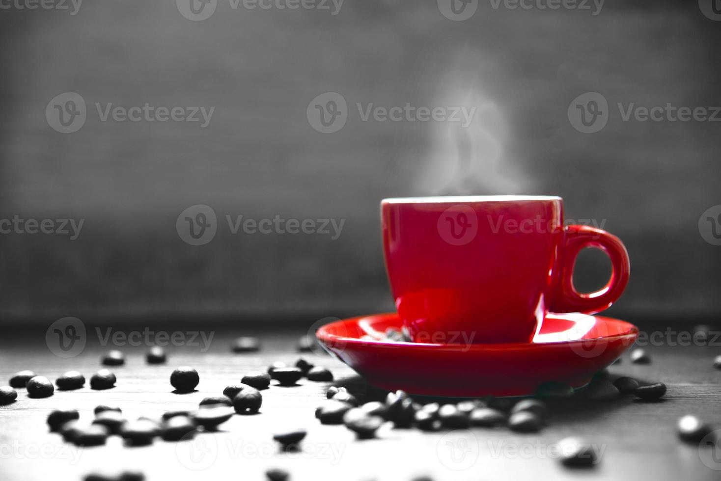 taza de café rojo con humo y grano de café foto