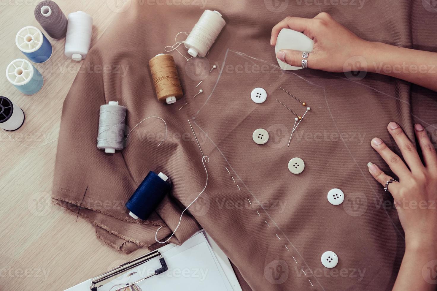 Top view of beautiful dressmaker sewing dress fabric photo