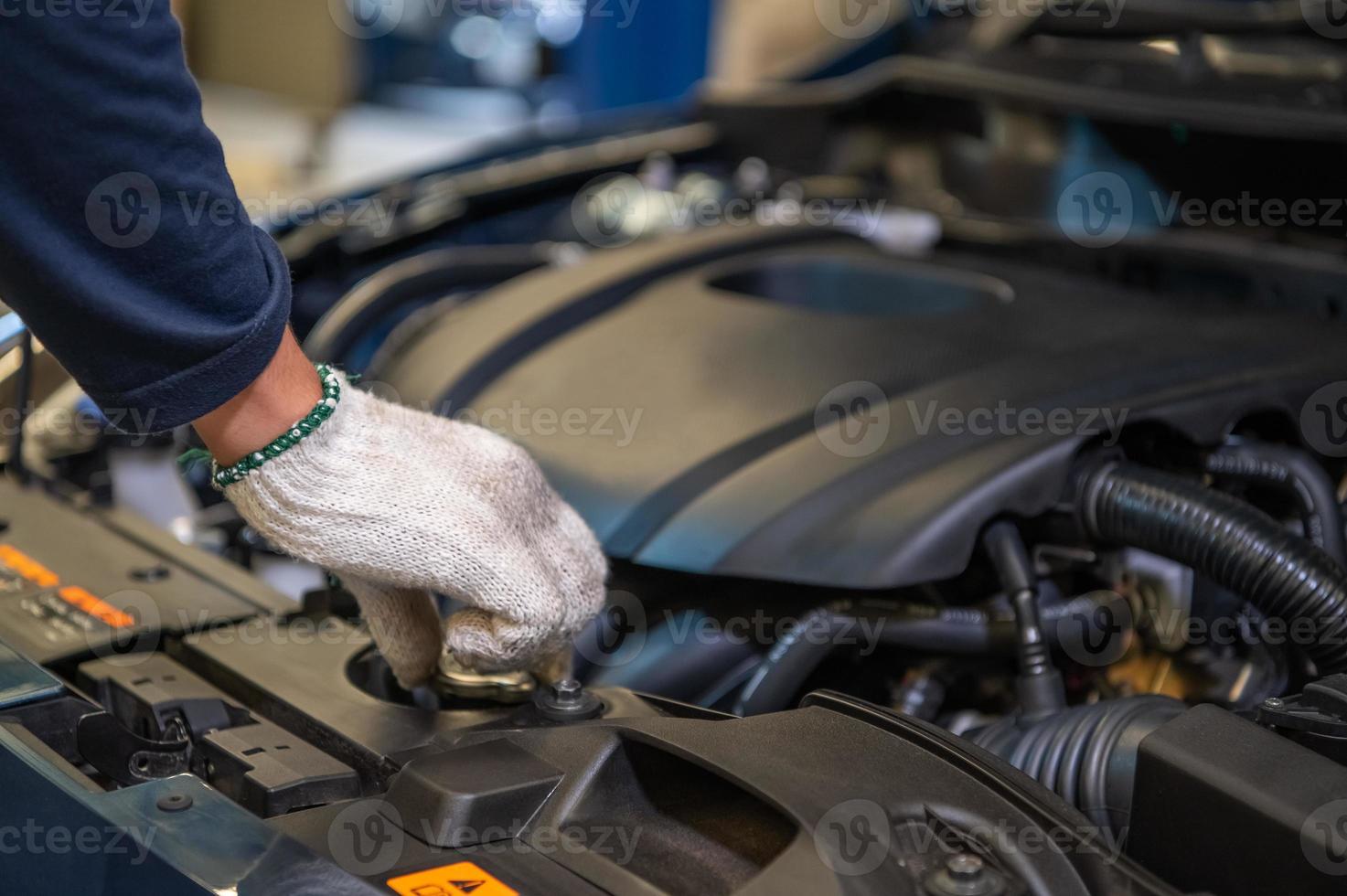 Primer plano de la mano del mecánico de automóviles examinar el problema de avería del motor del coche foto