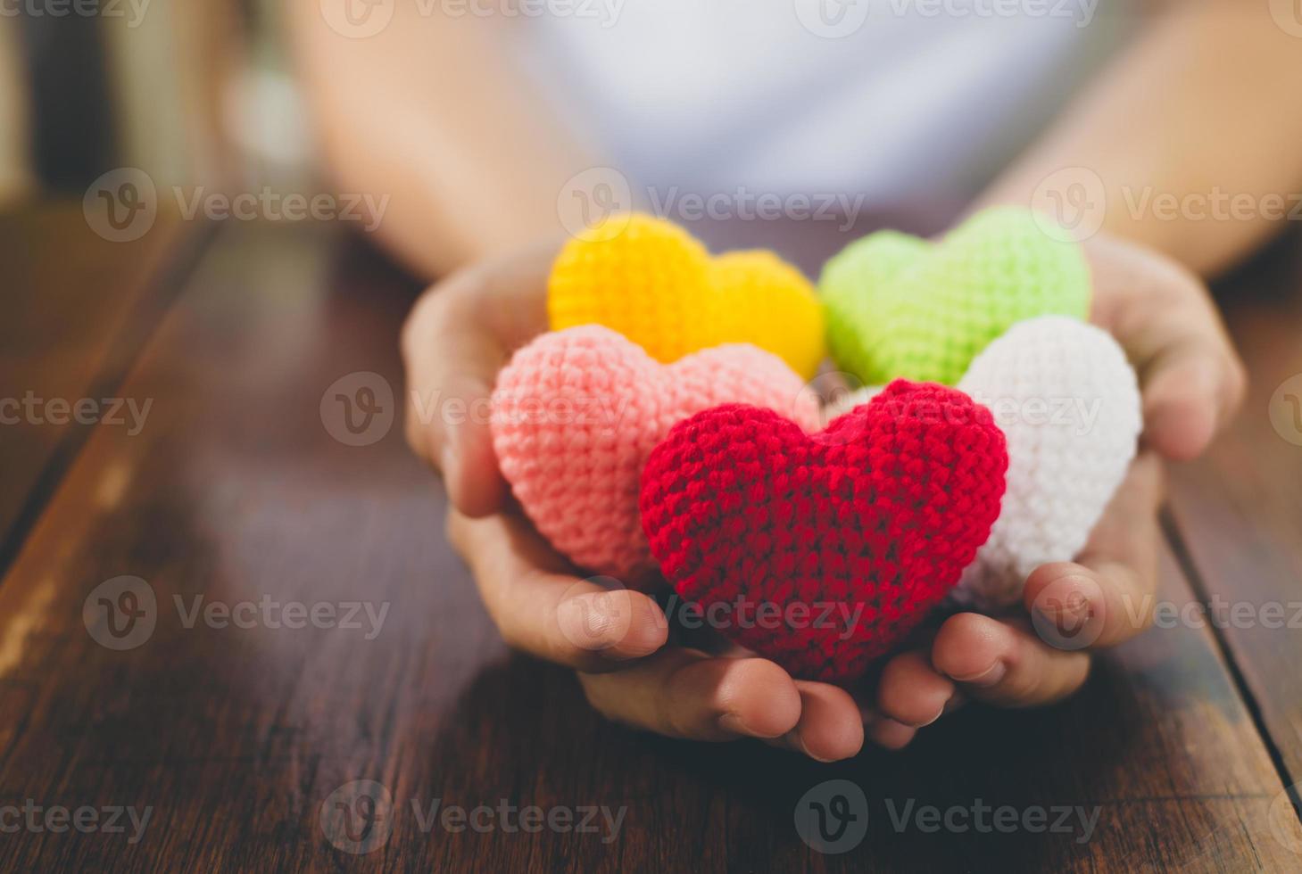 Corazón de hilo de colores mezclados en dar las manos foto