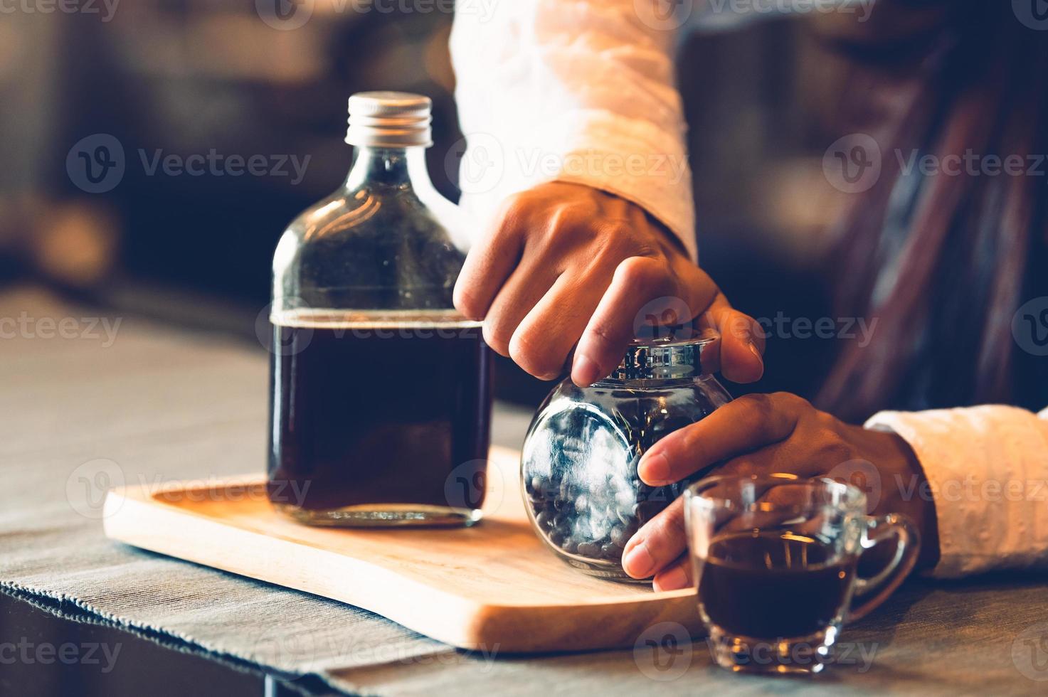 mujer profesional barista apertura de la mano botella de café foto
