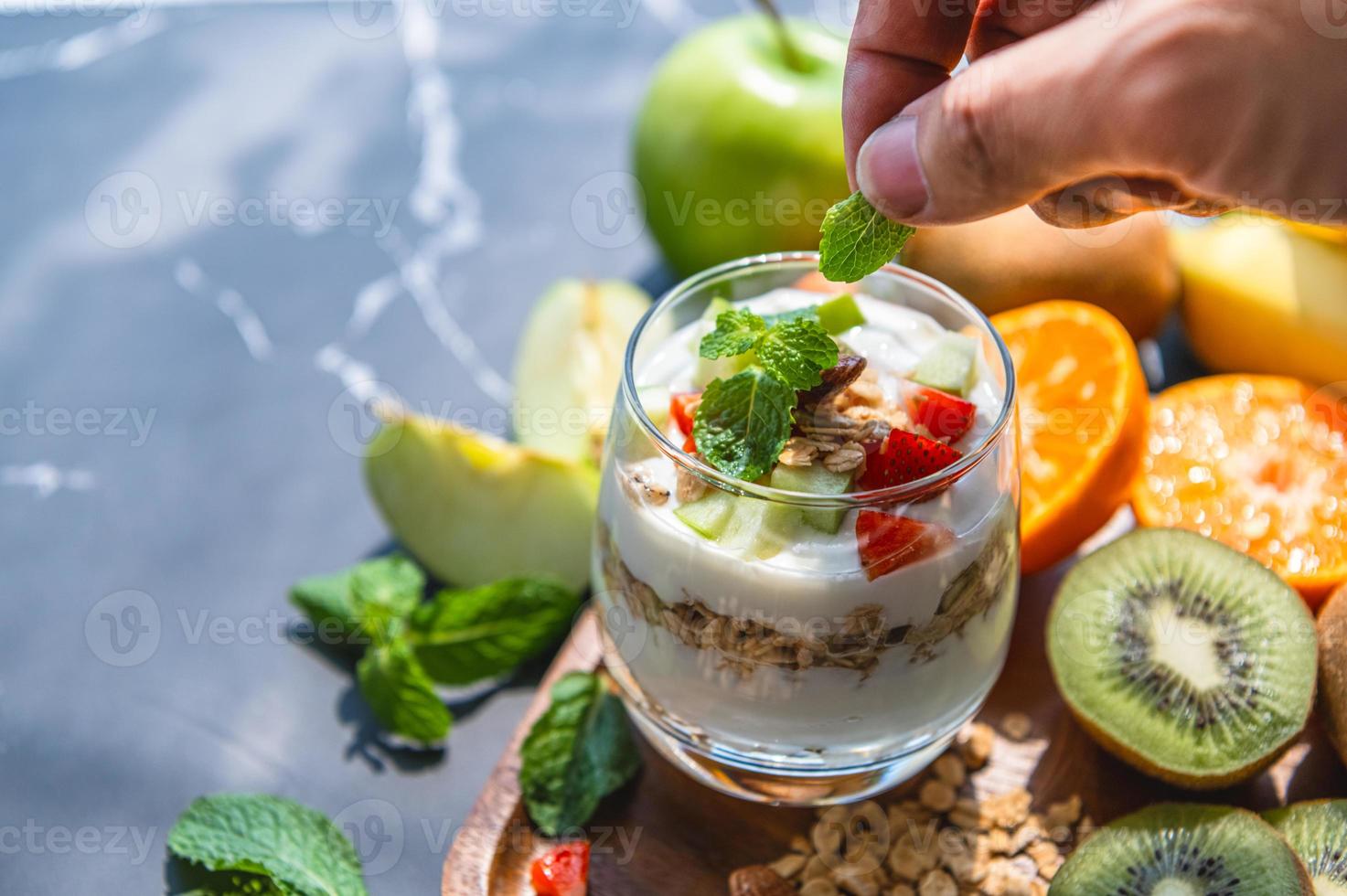 Primer plano de yogur de nutrición con muchas frutas en la mesa foto