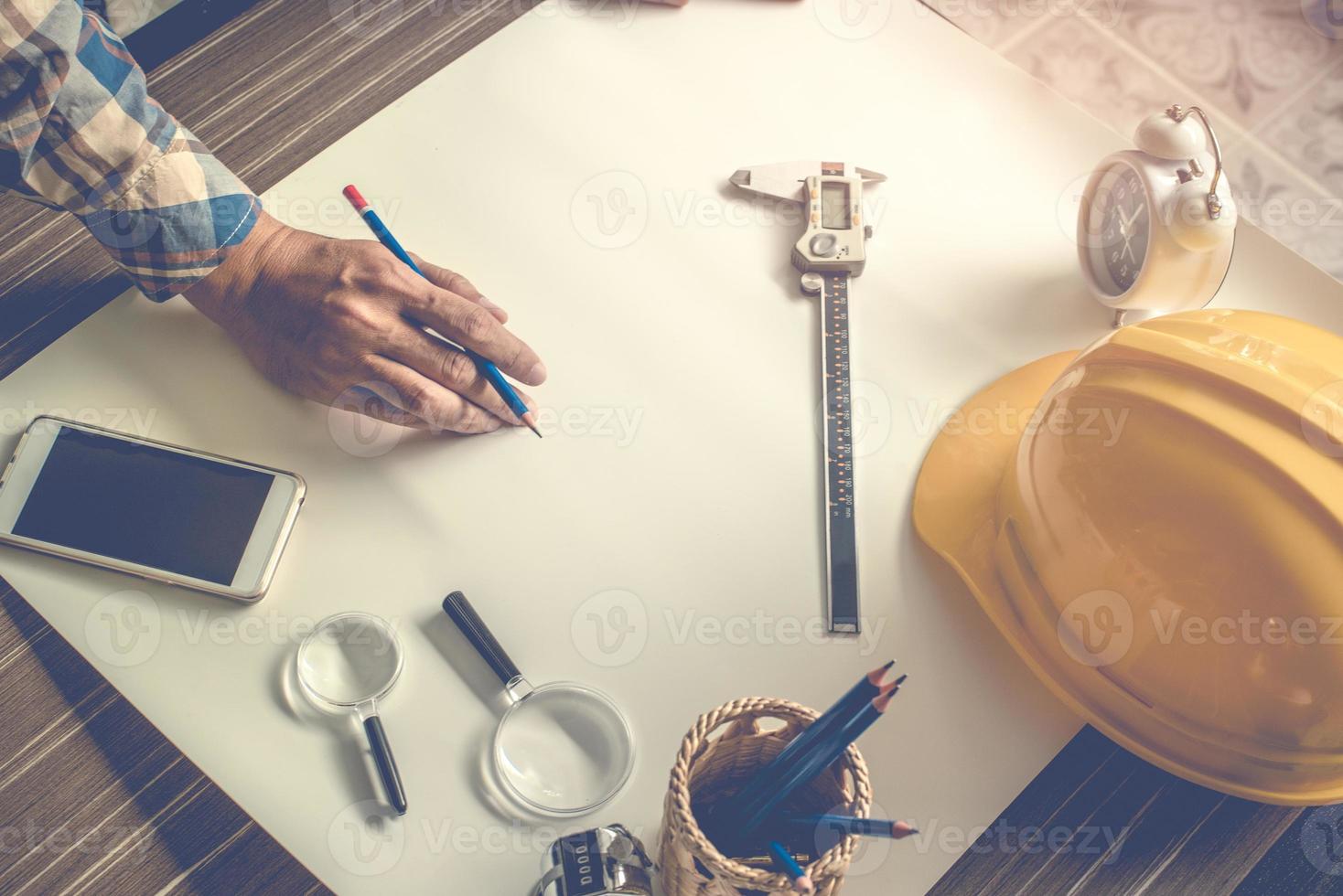 Ingeniero haciendo el borrador en blanco del dibujo sobre papel blanco foto