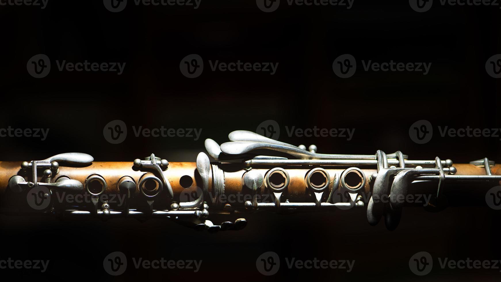 Ancient clarinet. Detail on a black background 3413543 Stock Photo at