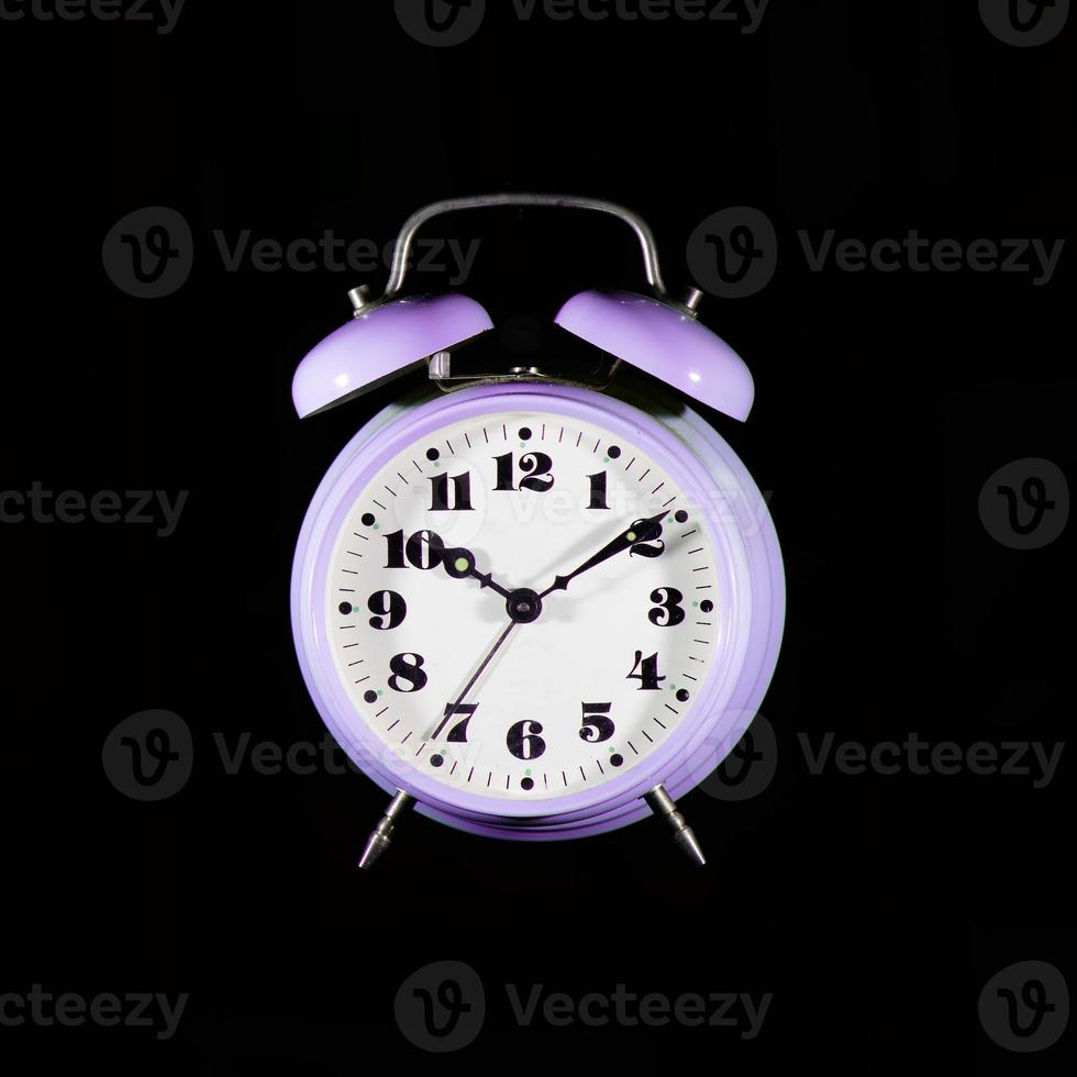 Classic purple table alarm clock on a black background photo