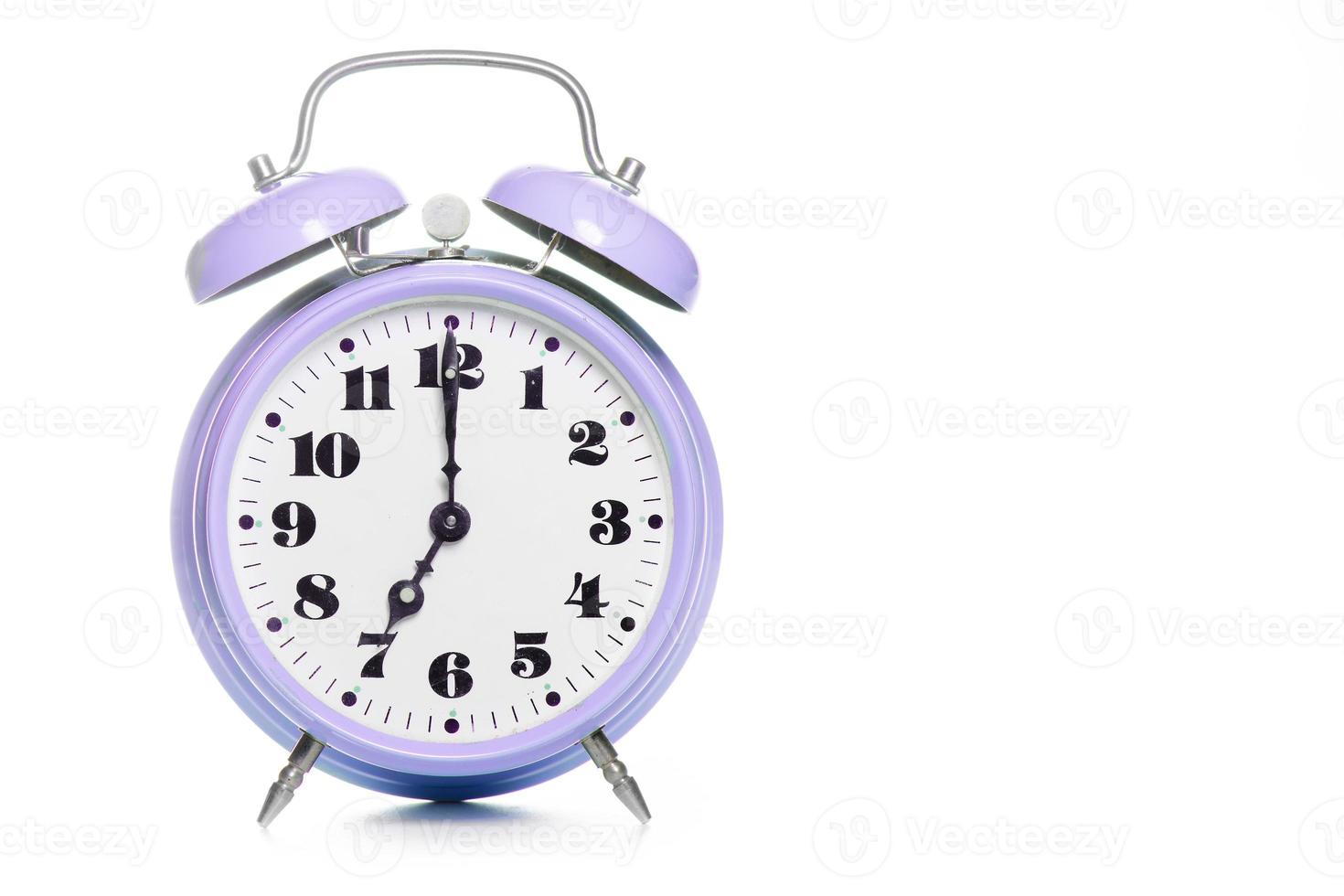 Clásico reloj despertador de mesa púrpura sobre un fondo blanco. foto