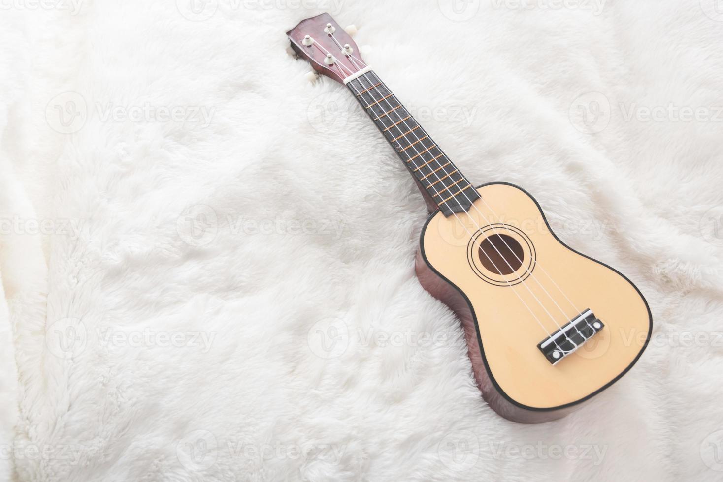 pequeña guitarra en lana blanca foto