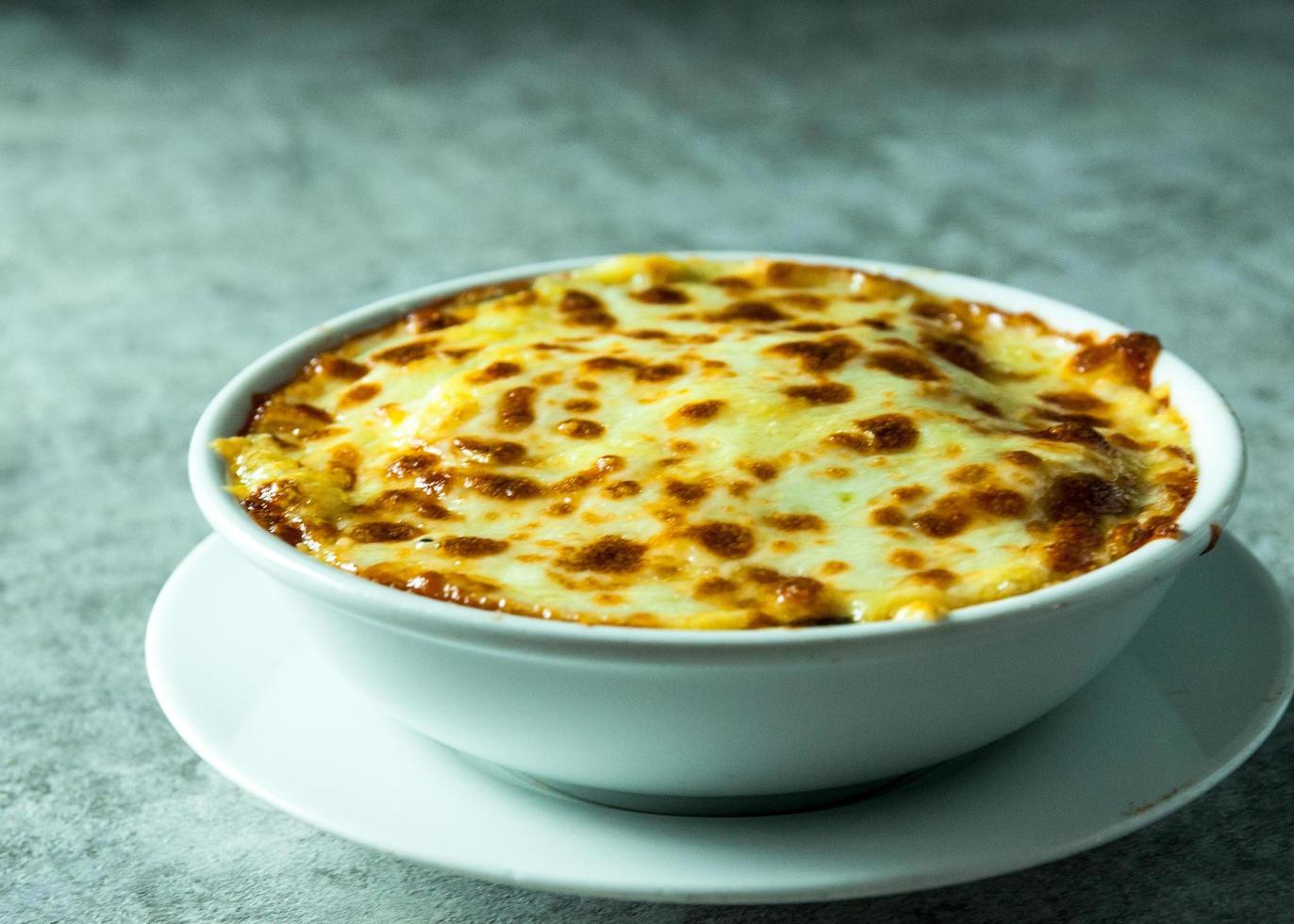 Lasaña de espinacas con queso en plato blanco foto