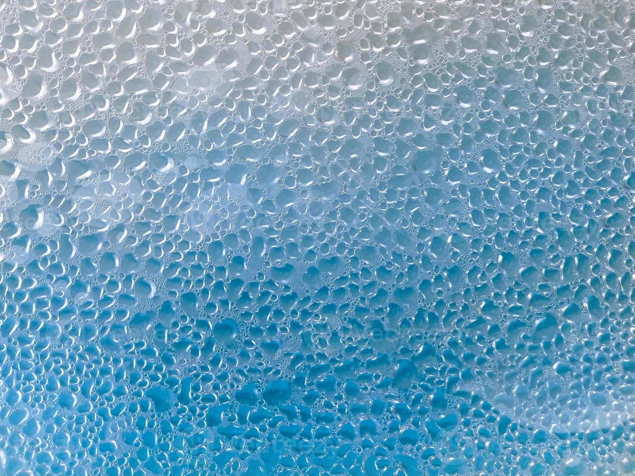 fondo azul de gotas de agua sobre el cristal foto