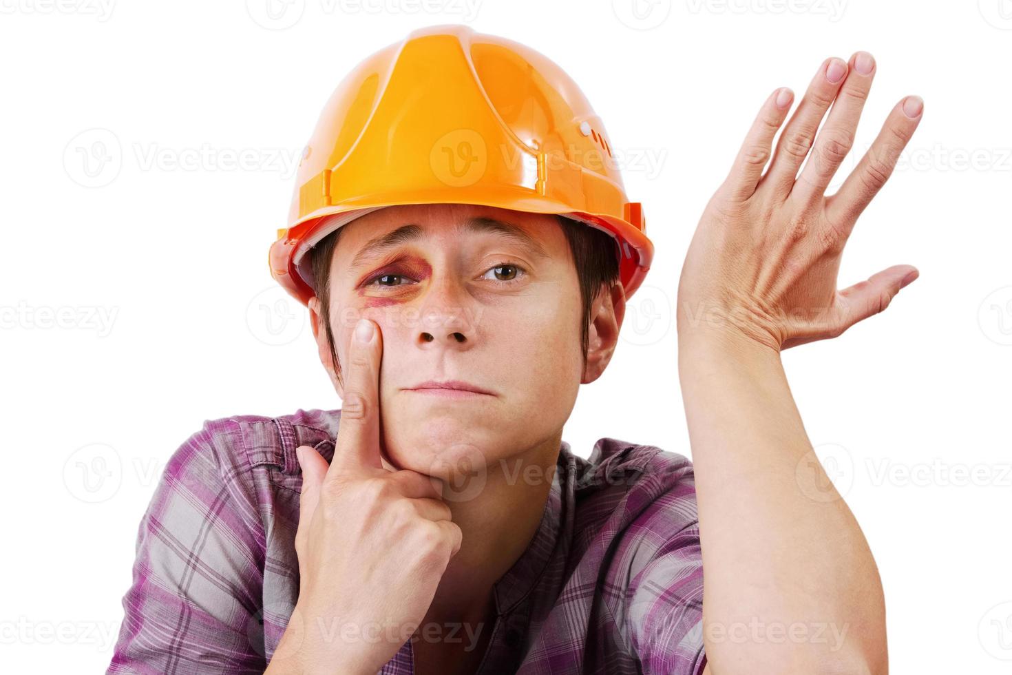 hombre con un ojo morado en un casco naranja foto