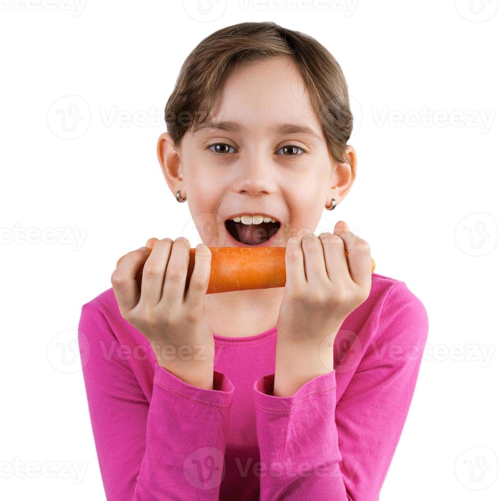 niña feliz comiendo una zanahoria grande foto