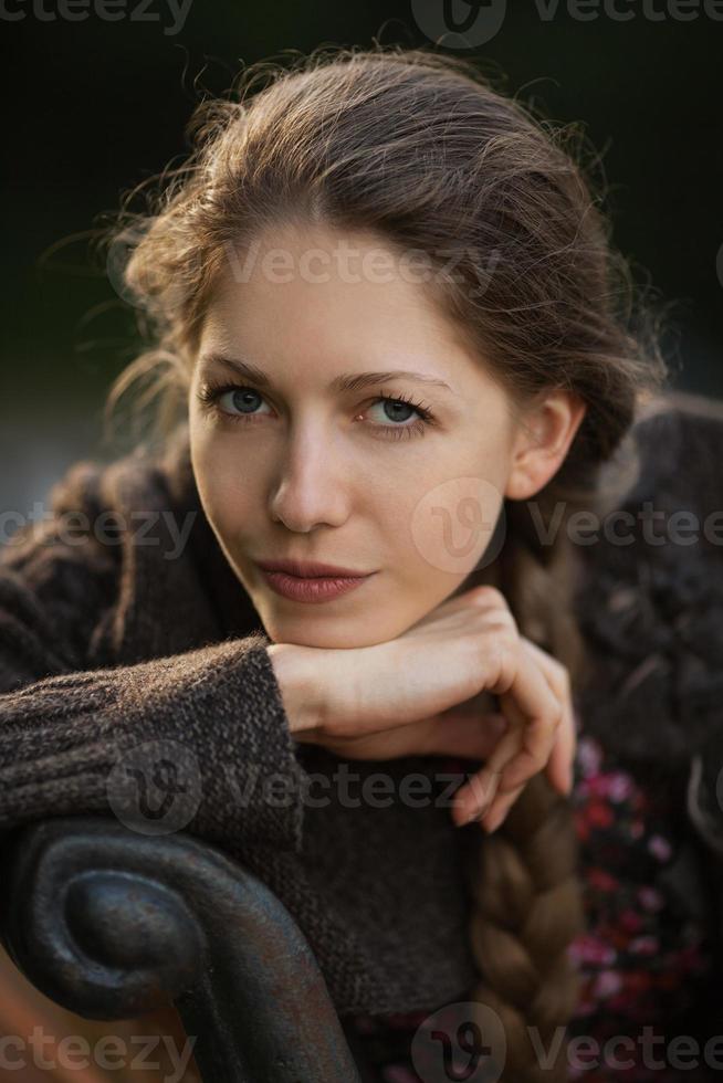 Beautiful woman sitting and looking to us photo