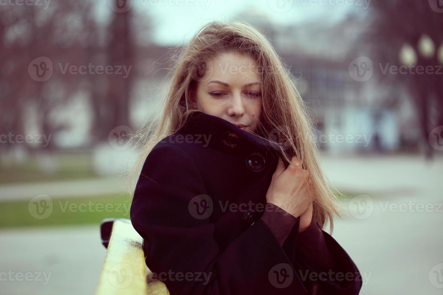 mujer joven envuelta en un abrigo del frío foto