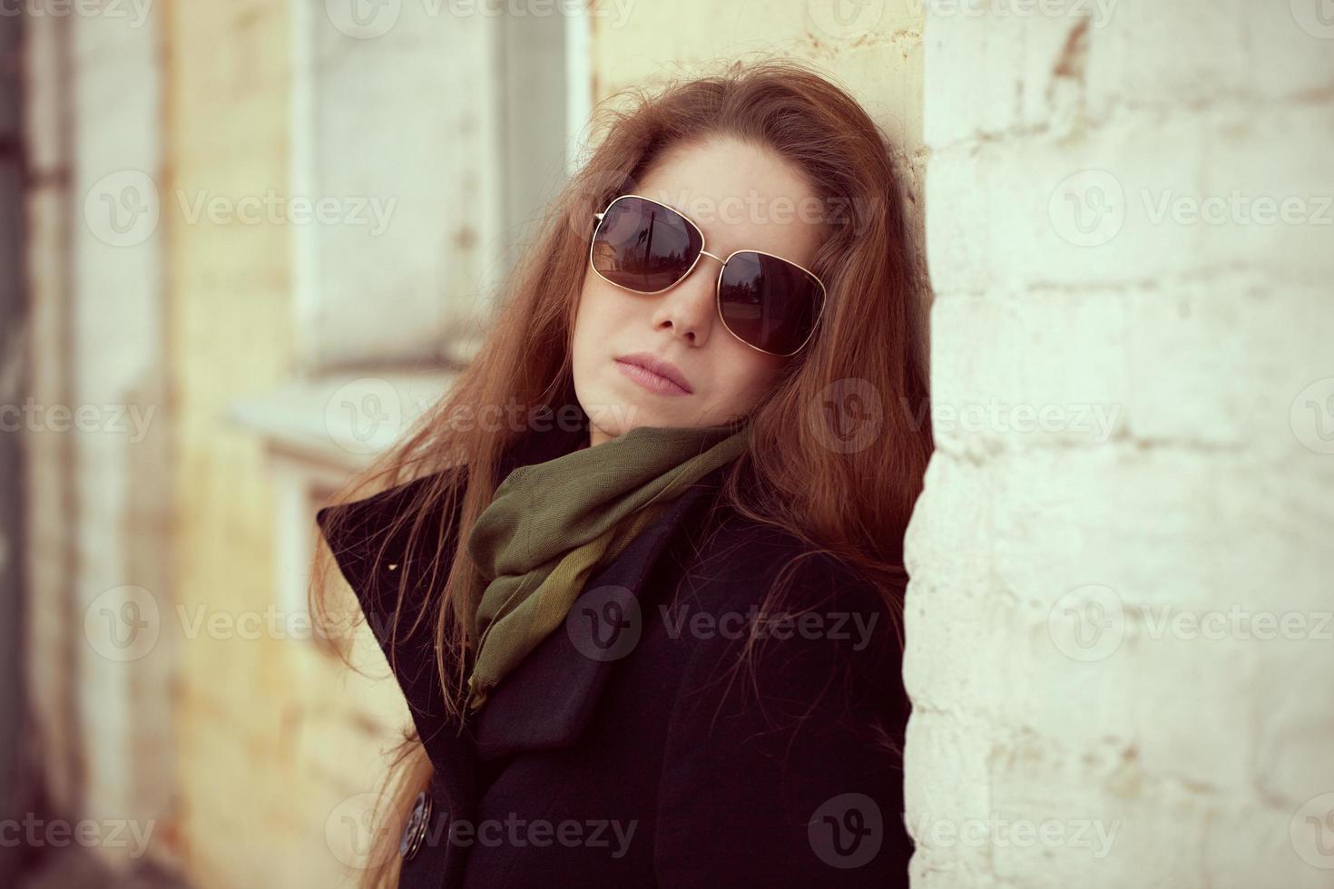 Pretty girl leaning on a wall photo