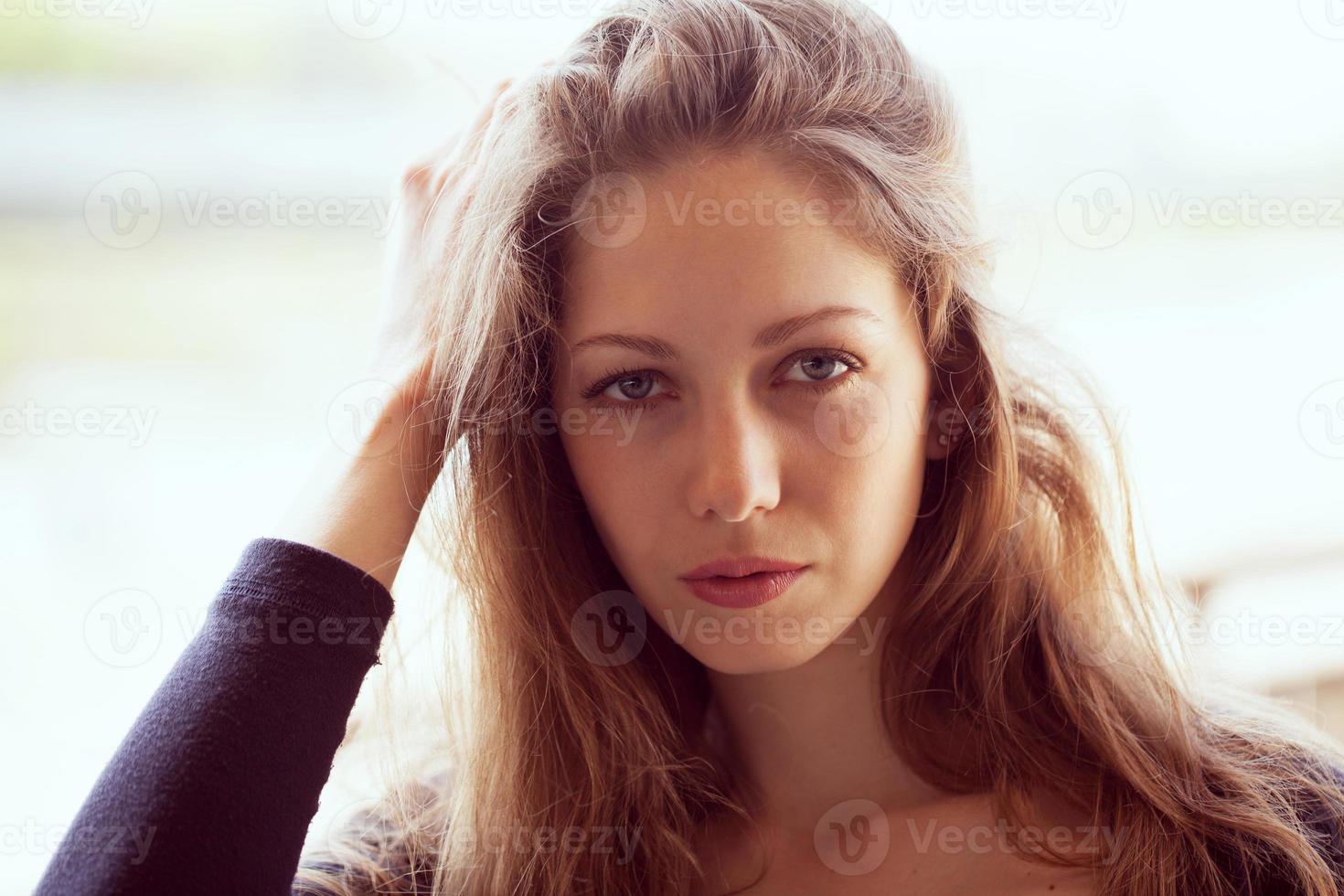 Beautiful woman straightens long dark hair photo