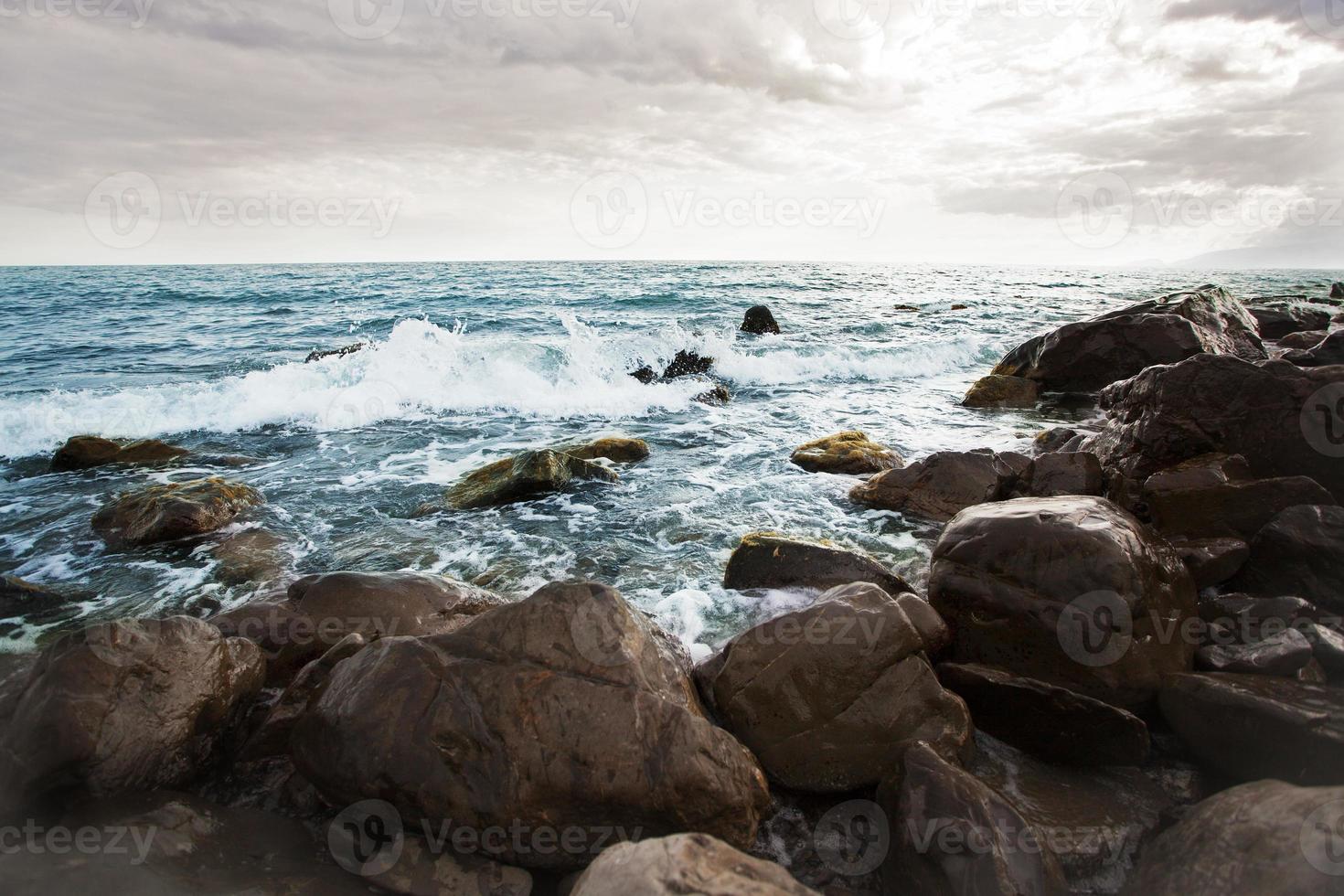 piedras en la playa bañadas por las olas foto