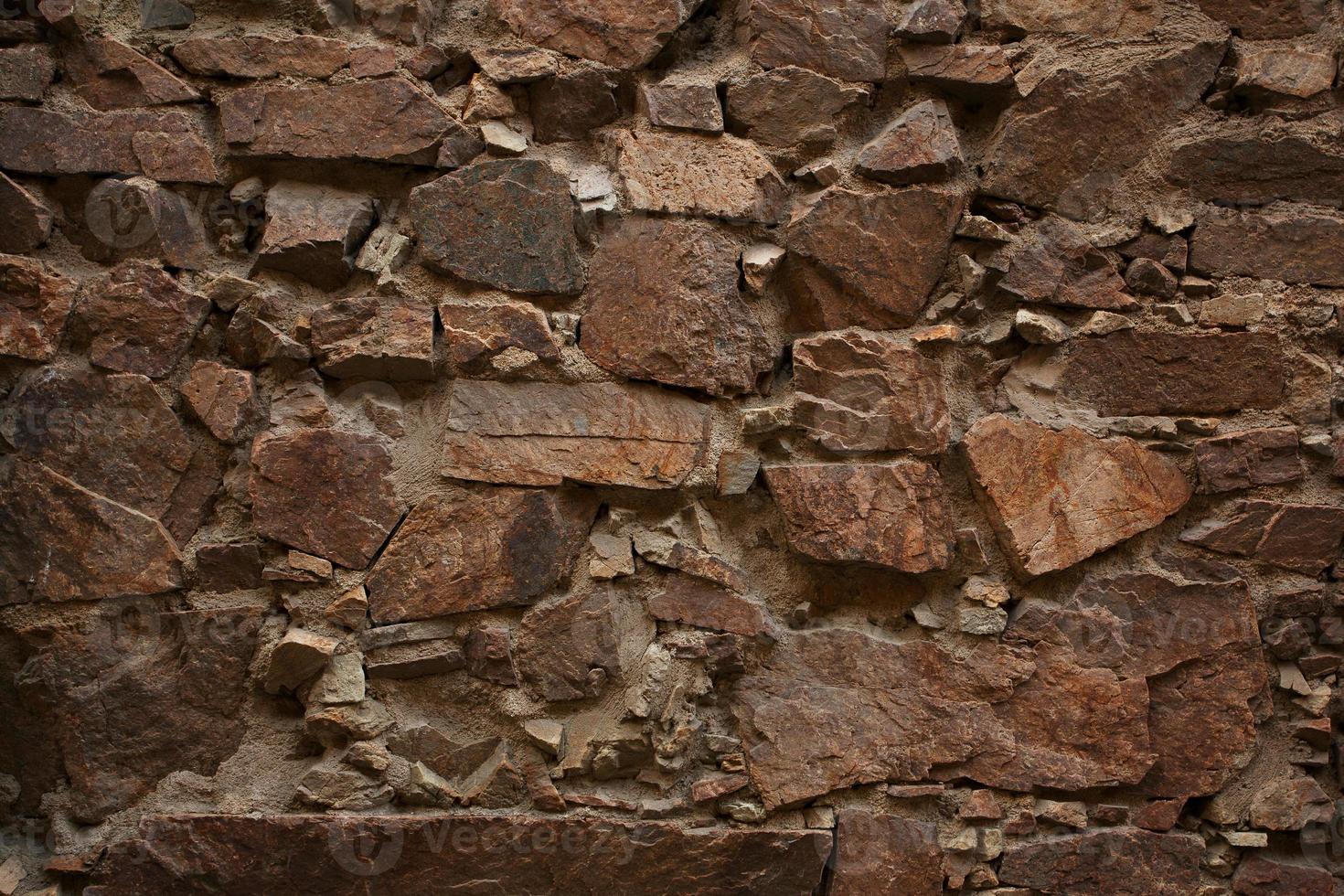 Ancient wall built of uncut bricks photo