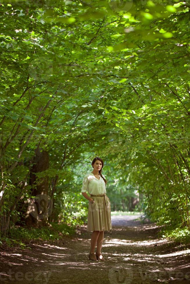 niña de pie en medio del callejón verde día de verano foto