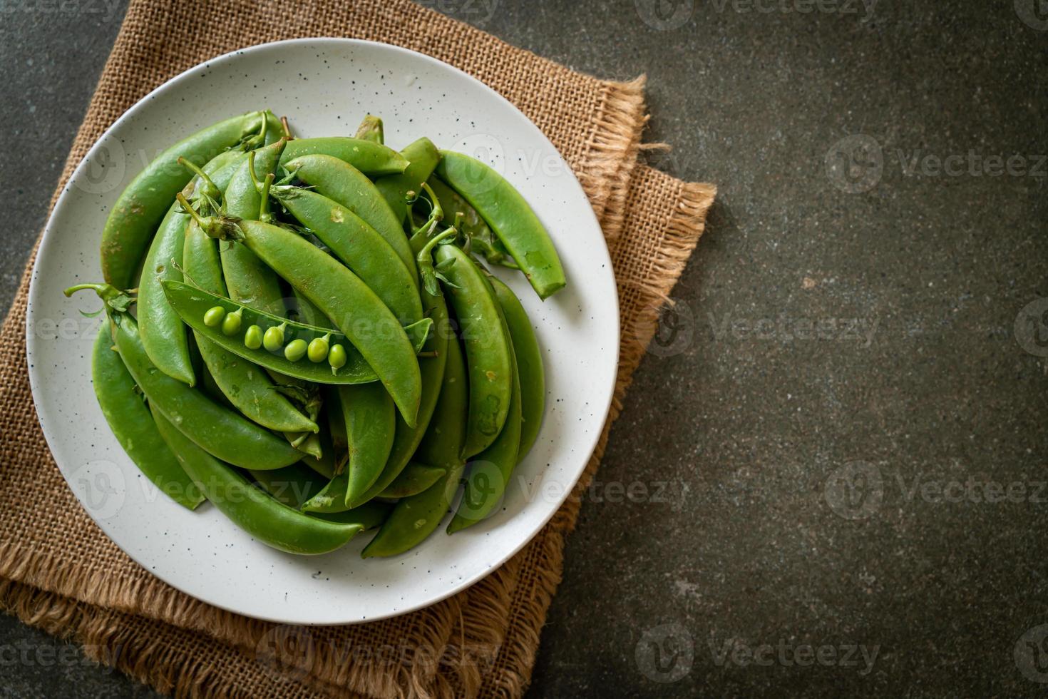 guisantes verdes dulces frescos en un plato foto