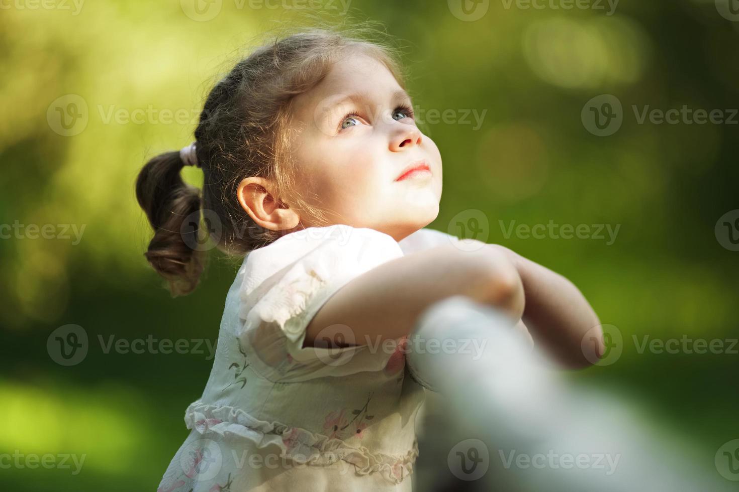 pequeña niña hermosa feliz mirando hacia arriba foto