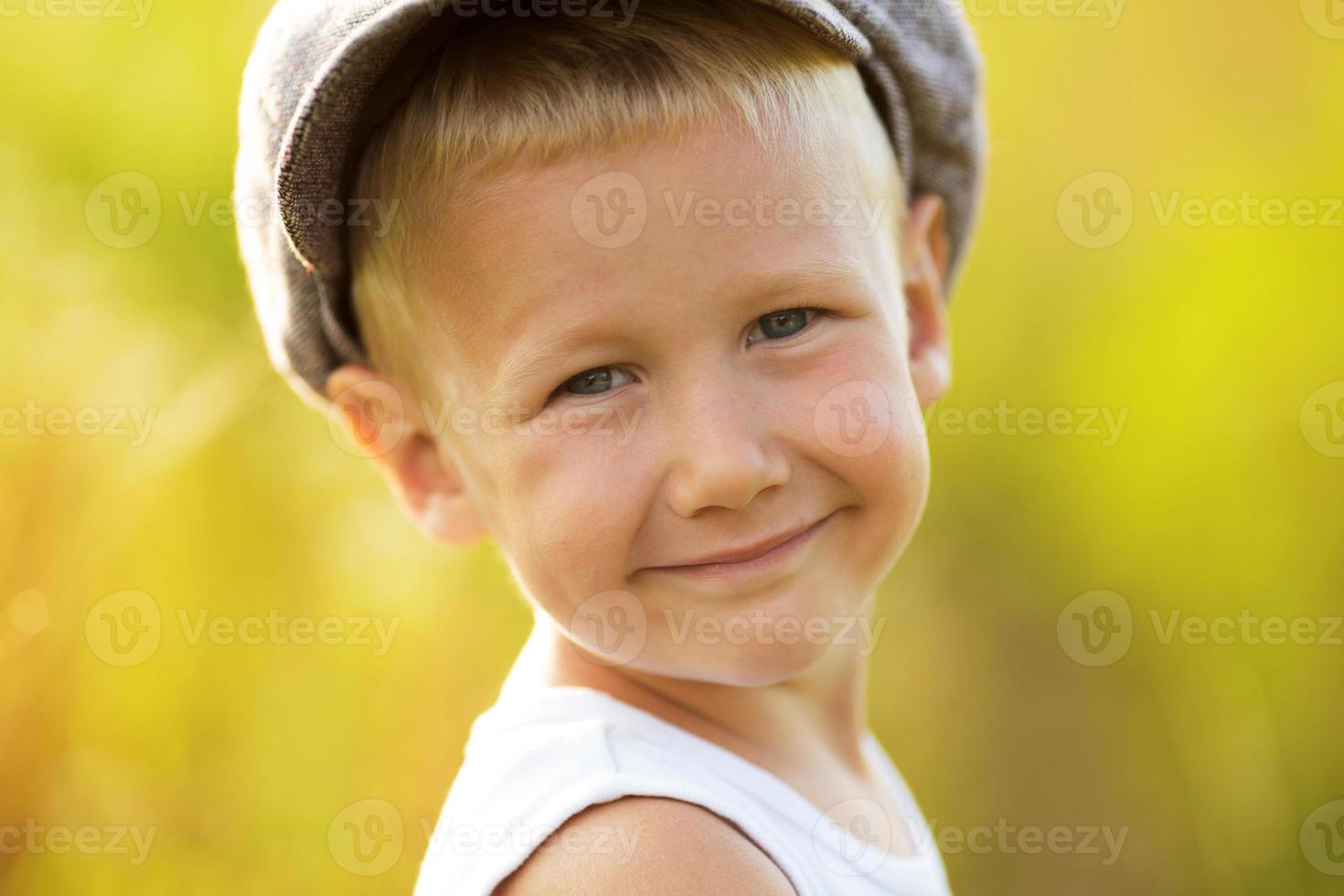 Happy smiling little boy in a cap photo