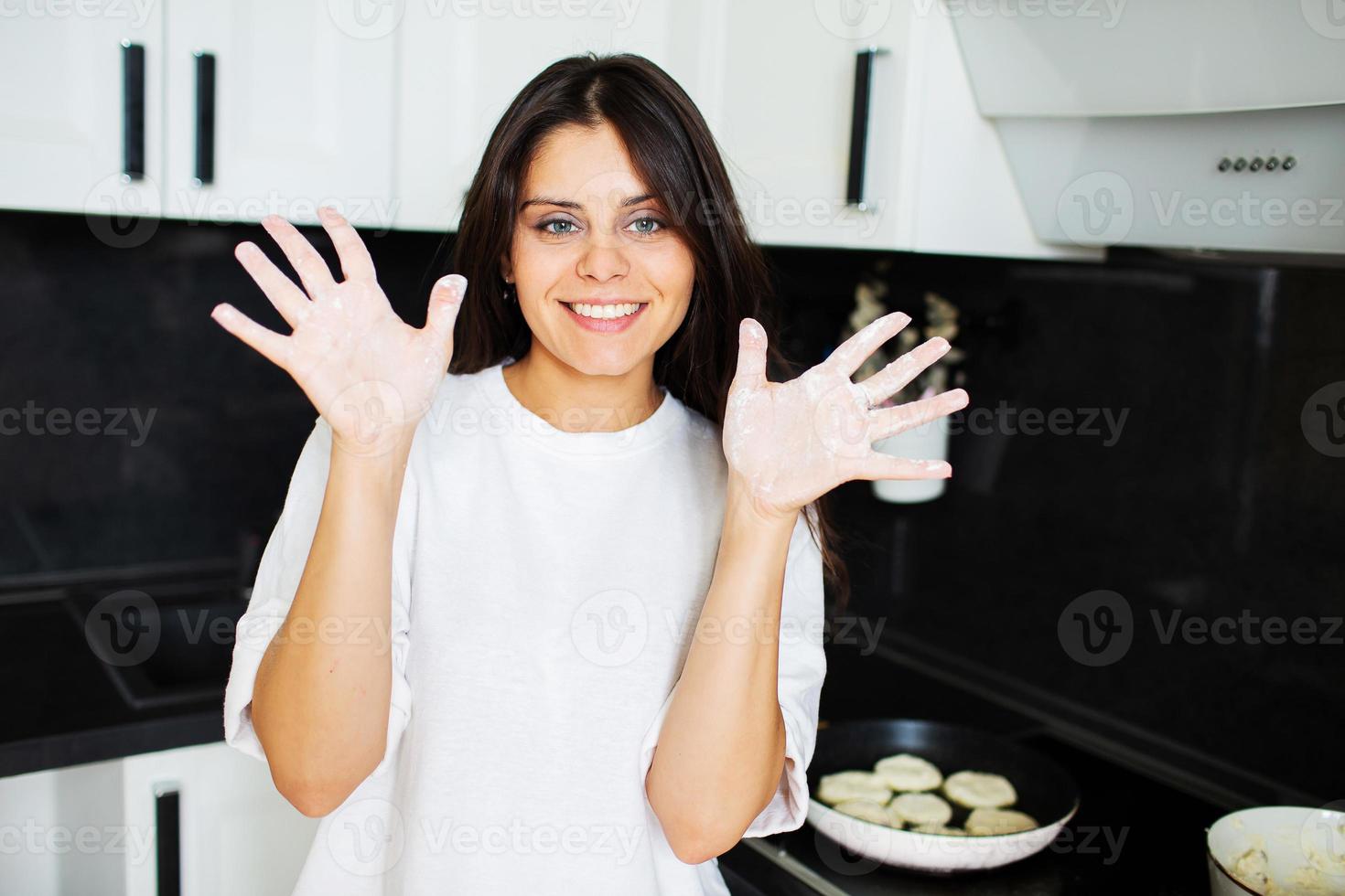 mujer joven nos muestra sus manos, untadas con harina foto