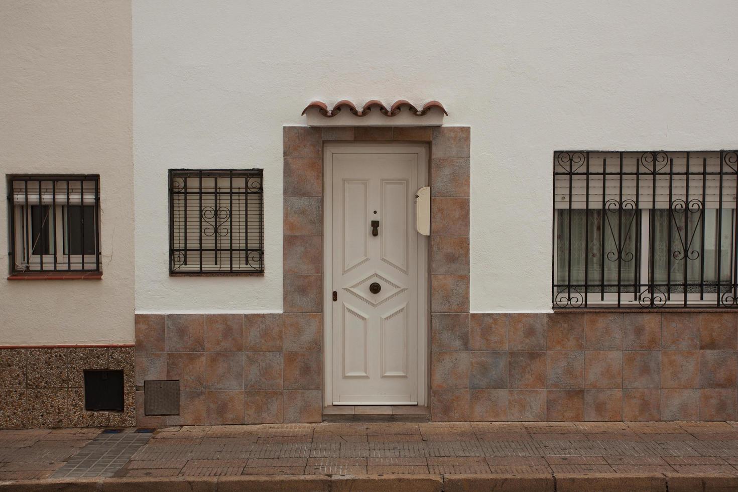 Puerta de madera en una casa de estuco blanco foto